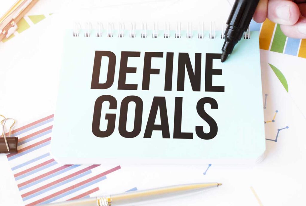 hand,paper plate,marker, diagram,chart and office tools. Text DEFINE GOALS